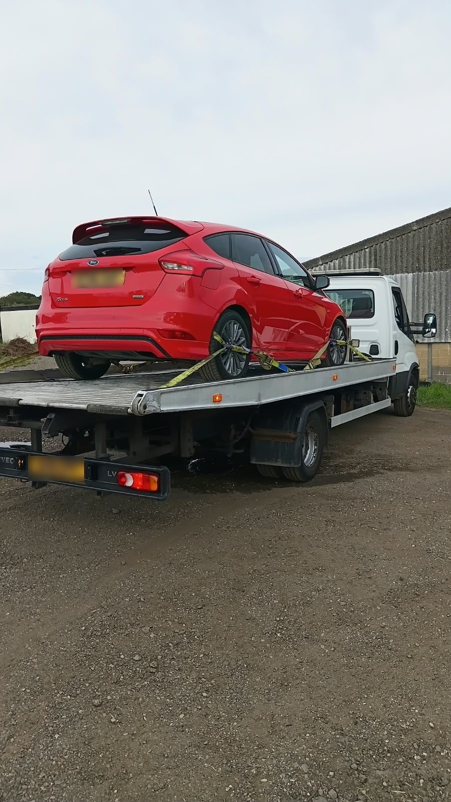 Red Ford Focus on a recovery truck for car breakdown recovery