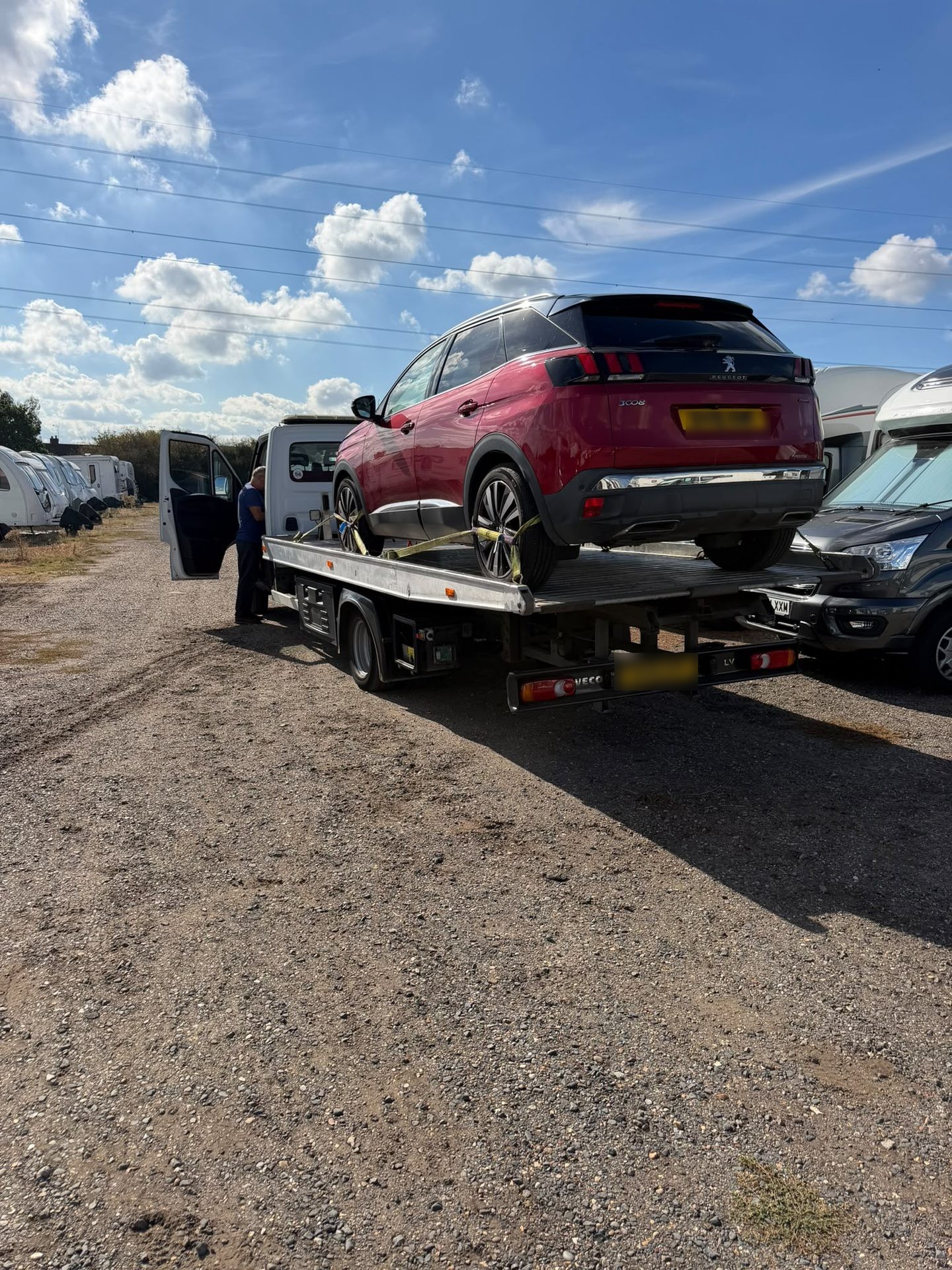 Red Peugeot SUV on a transporter truck for vehicle transportation